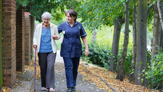 caregiver walking with elderly lady 