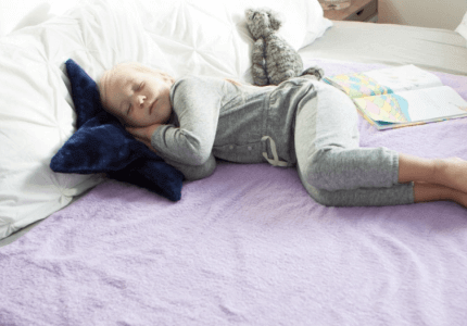 Young girl sleep on top of large PeapodMat in Mauve It colour