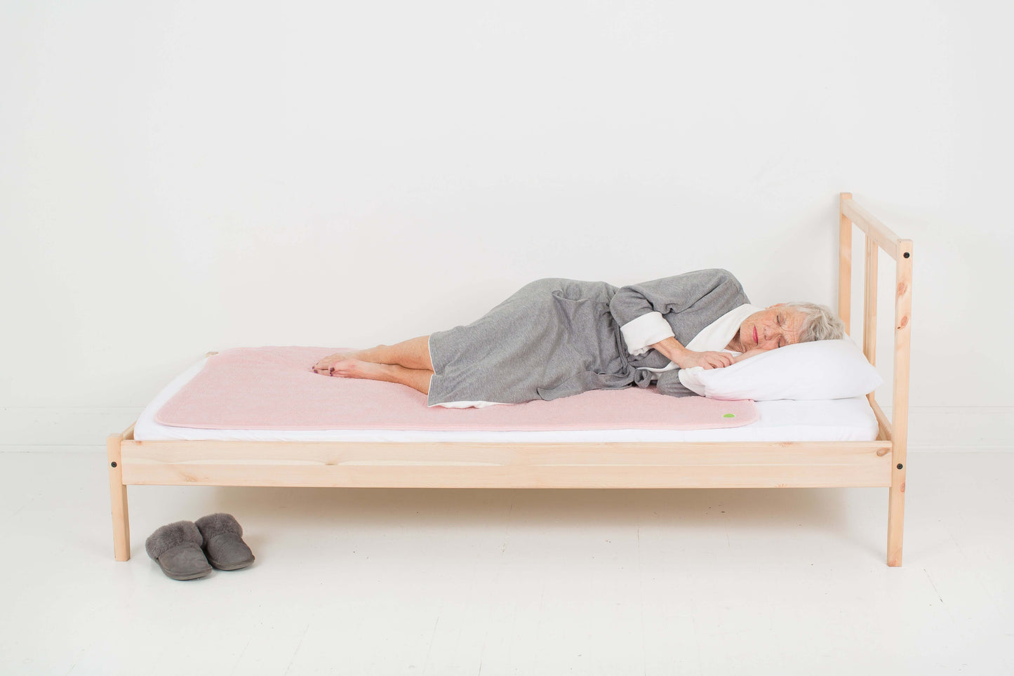 woman sleeping on top of the large PeapodMats in Fuzzy Peach colour