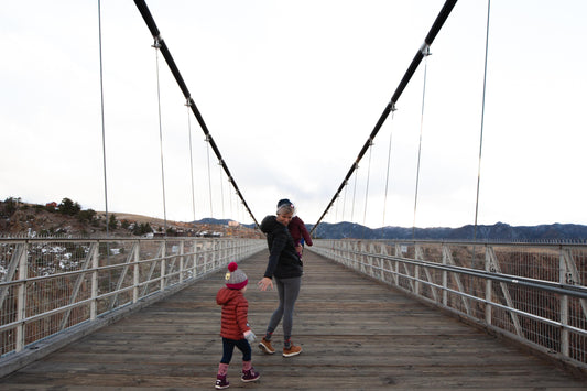 parent and toddler walking across bridge