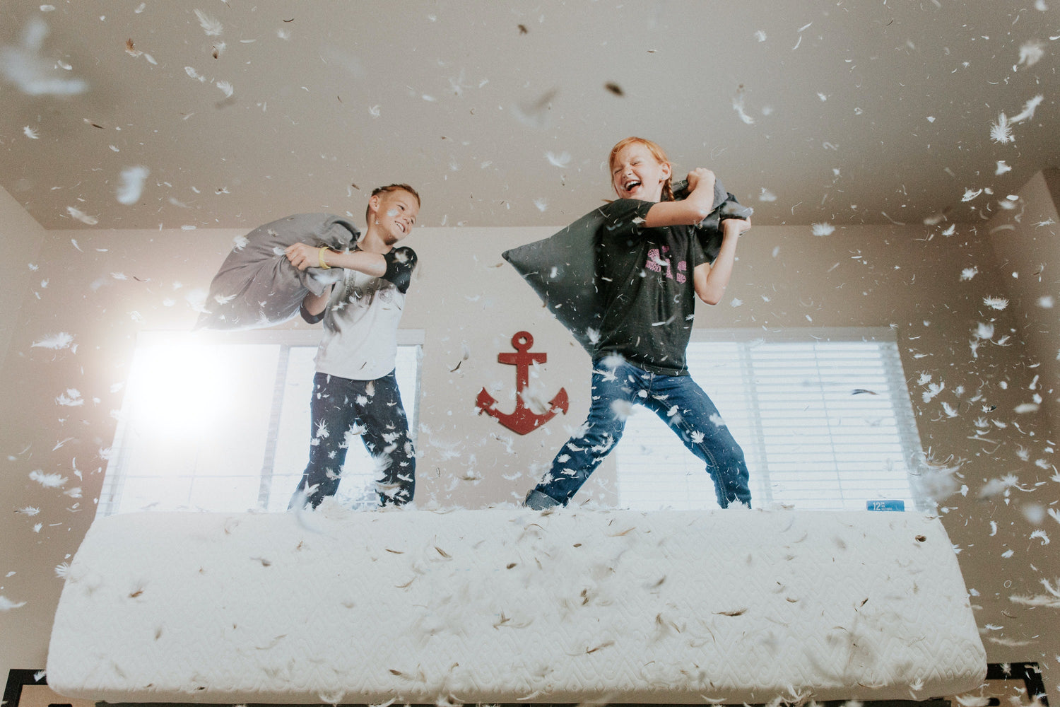 Two kids having a pillow fight