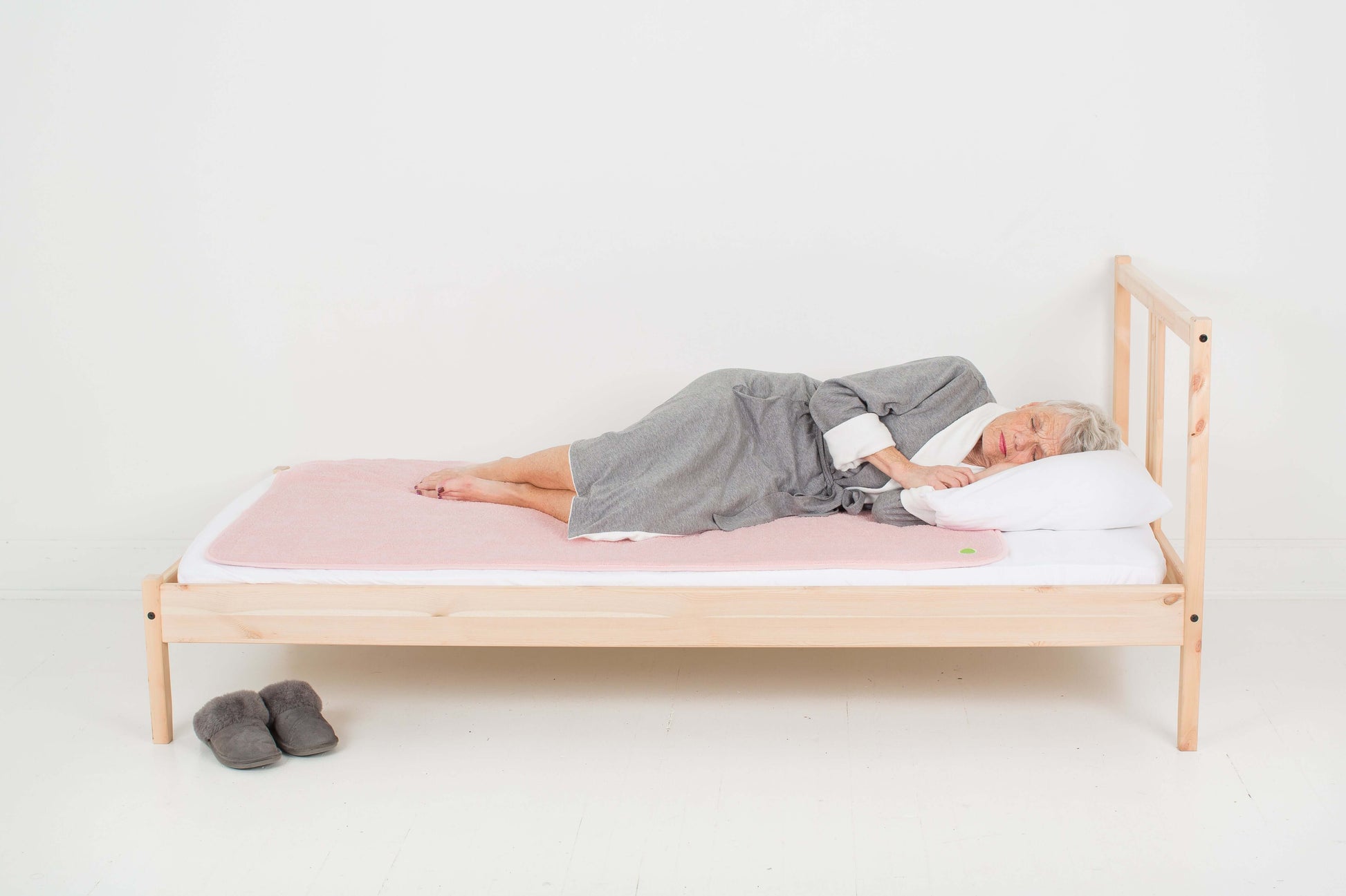 woman sleeping on top of the  large PeapodMats in Fuzzy Peach colour