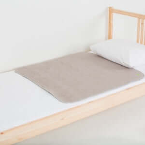Medium PeapodMat on top of single bed in Sandman colour